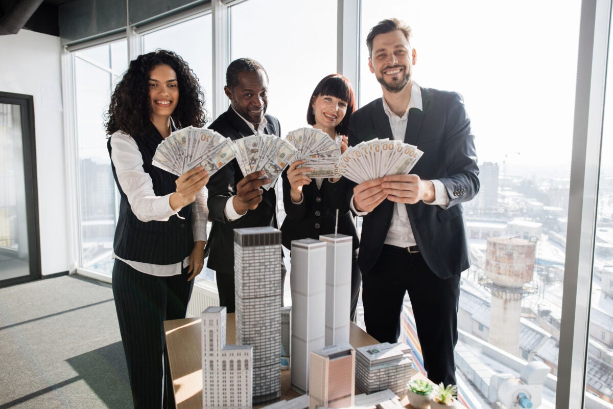 Real estate agents holding bundles of cash
