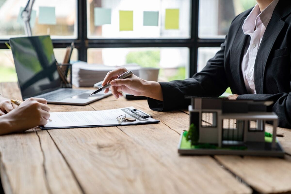 Two people sitting at a desk reviewing a contract.