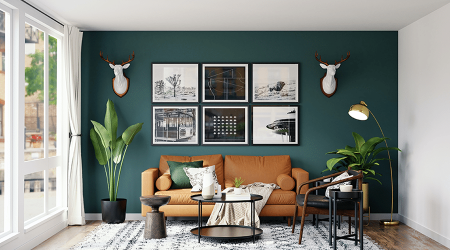 A living room with a brown couch, frames on the wall, and potted plants on the side